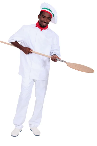 Jonge zwarte pizza cook nemen een spade — Stockfoto