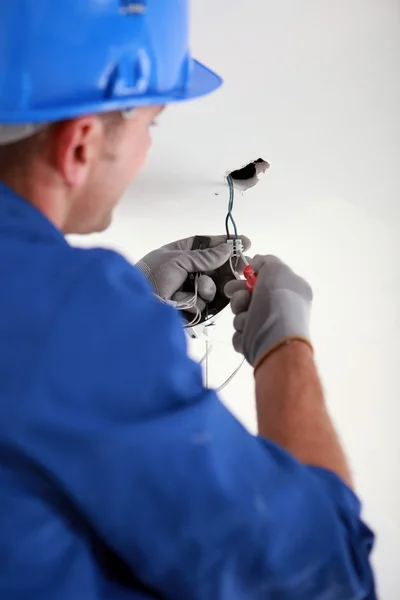 Electrician fixing electrical wiring — Stock Photo, Image