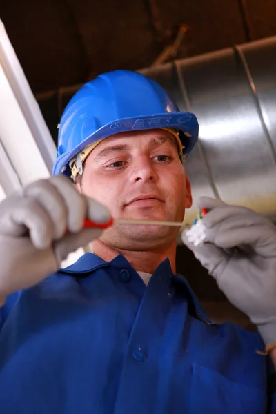 Electrician screwing a piece — Stock Photo, Image