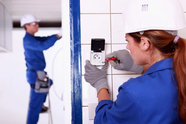Female electrician installing a continental socket — Stock Photo, Image