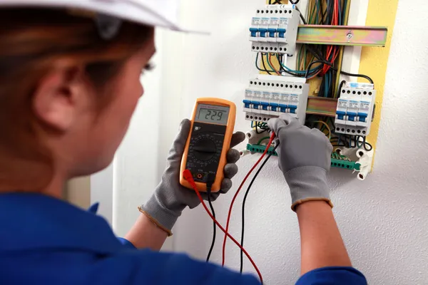 Female electrician checking a fusebox — Stock Photo, Image