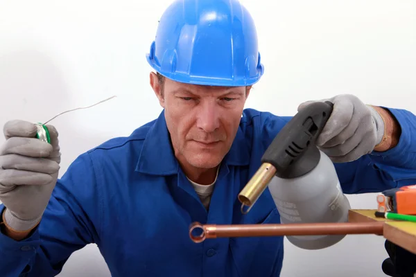 Artigiano saldando un tubo di rame — Foto Stock