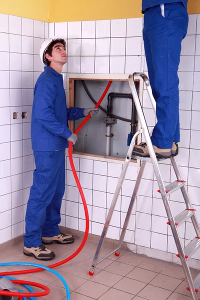 Two plumber fixing bathroom water supply — Stock Photo, Image