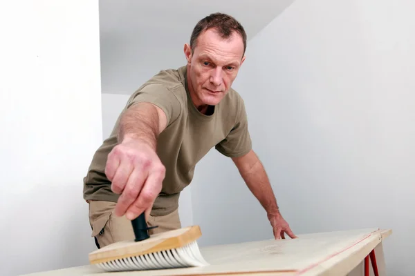 Człowiek zamiatanie powierzchni drewnianych — Zdjęcie stockowe