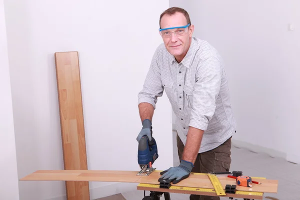 Man cutting floorboard — Stock Photo, Image