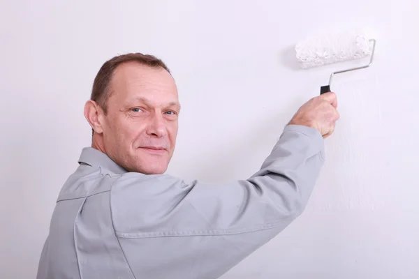 Homme peignant un mur intérieur blanc — Photo