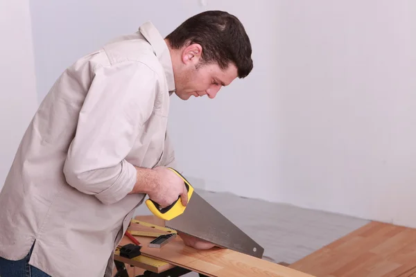 Man sawing laminate flooring — Stock Photo, Image