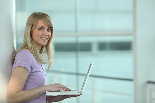 Lässige blonde Frau mit Laptop — Stockfoto
