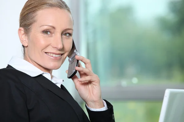 Geschäftsfrau telefoniert am Fenster. — Stockfoto