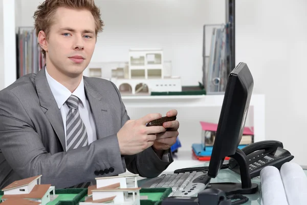 An architect texting in his office. — Stock Photo, Image