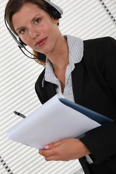 Büroangestellte mit Headset und Klemmbrett — Stockfoto