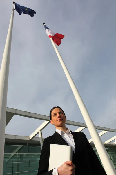 Γυναίκα να στέκεται δίπλα στην γαλλική και Ευρωπαϊκή κοντάρια σημαίας — Φωτογραφία Αρχείου