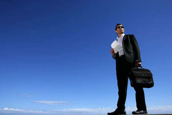 Selbstbewusster Geschäftsmann vor blauem Himmel — Stockfoto