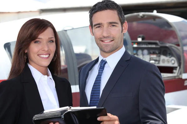 Couple standing by the cockpit of a light aircraft — Stock Photo, Image