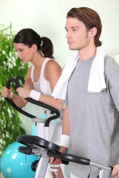 Casal jovem usando equipamentos de ginásio — Fotografia de Stock