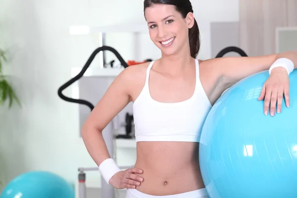 Женщина с мячом для упражнений в спортзале — стоковое фото