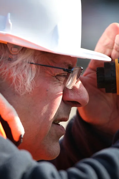 Landvermessungsingenieur blickt in einen Altometer — Stockfoto