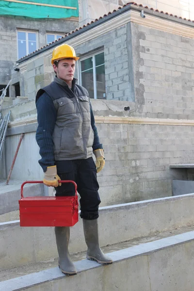 Trabajador de la construcción en el sitio con una caja de herramientas —  Fotos de Stock