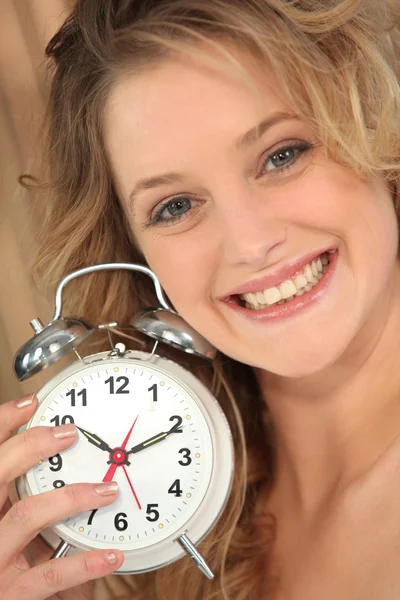 Mujer rubia sosteniendo reloj despertador — Foto de Stock