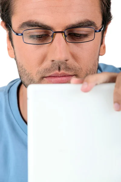 Homem de óculos olhando para seu laptop — Fotografia de Stock