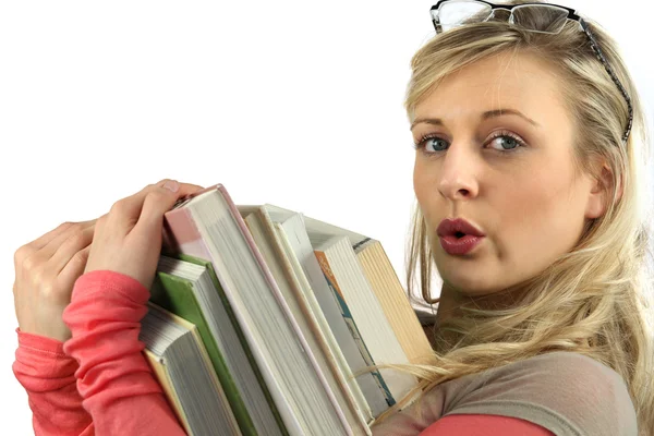 Ung kvinna med en hög med böcker i famnen — Stockfoto