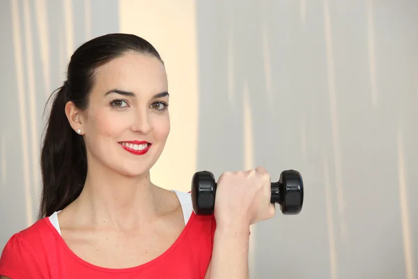 Woman lifting a dumbbell — Stock Photo, Image