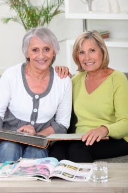 Duo of grandmothers skimming through album clipart