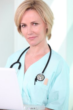 A medical professional looking at her laptop clipart