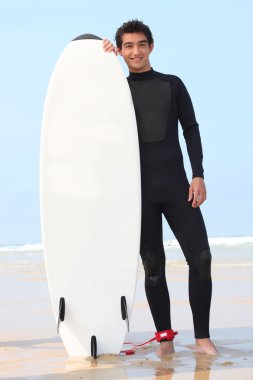 Young surfer posing with board clipart