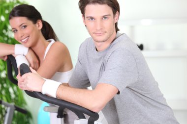 Couple using running machines clipart