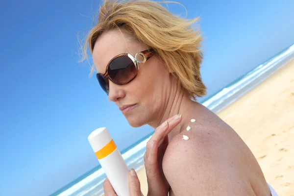 Woman putting on sun cream — Stock Photo, Image