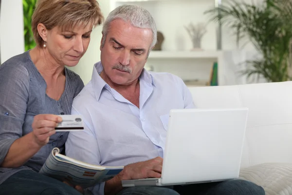 Ein älteres Paar kauft im Internet ein — Stockfoto