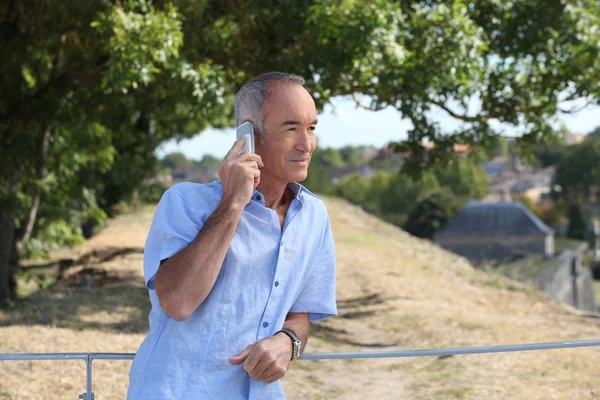 Senior in the country talking on his cell phone — Stock Photo, Image