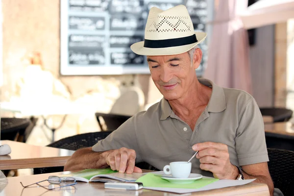 Старший джентльмен наслаждается свободным временем в кафе — стоковое фото