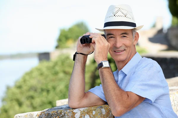 Senior gentleman admiring view with binoculars — Stock Photo, Image
