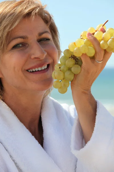 Vrouw bedrijf druiven — Stockfoto