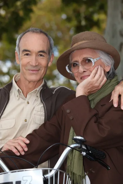 Elderly couple with bicycle — Stock Photo, Image