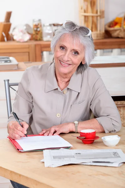 Una donna anziana che scrive una lettera — Foto Stock