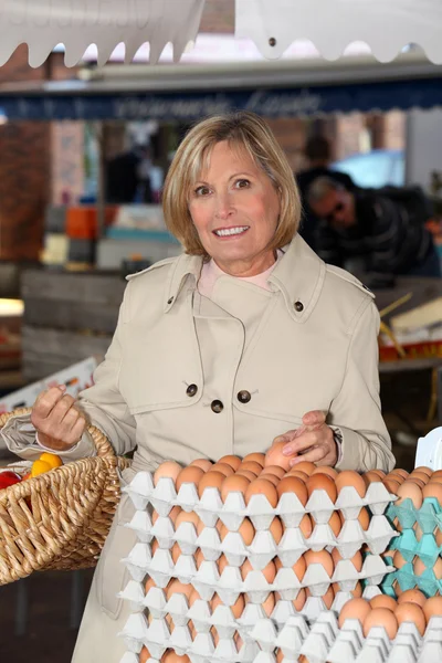 Frau kauft Eier auf Markt — Stockfoto