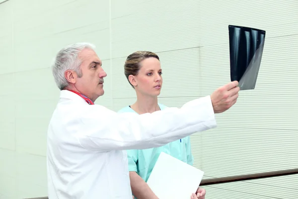 Dottore e il suo assistente esaminando una radiografia — Foto Stock