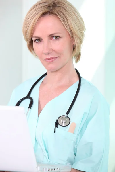 En medicinsk professionell tittar på hennes laptop — Stockfoto