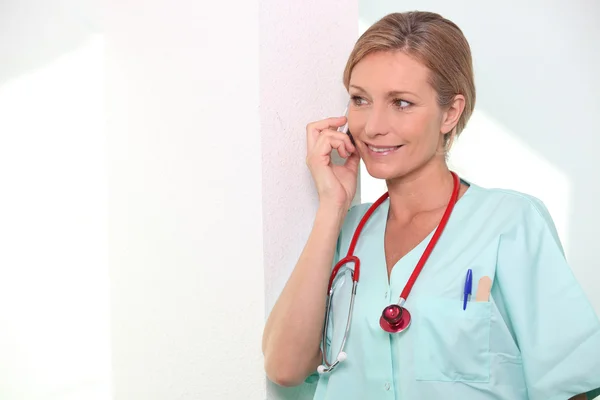 Kvinnlig sjuksköterska på mobil telefon — Stockfoto