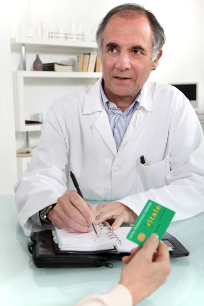 Woman giving a card to a doctor — Stock Photo, Image