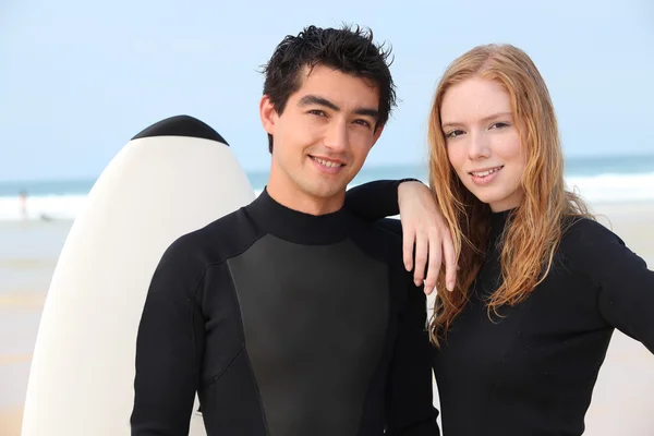 Junges Surfer-Paar in Neoprenanzügen — Stockfoto