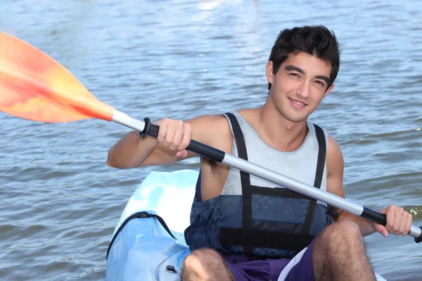 Junger Mann lächelt im Kanu — Stockfoto