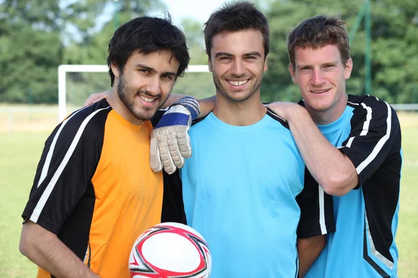 Трое футболистов в повседневной одежде позируют для фото — стоковое фото