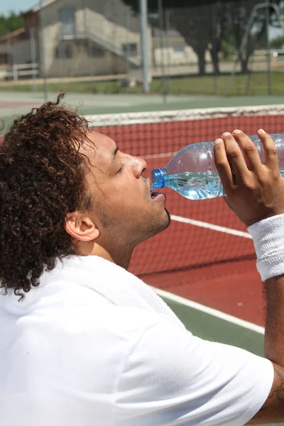 Male tennis player drinking water — Stock Photo, Image