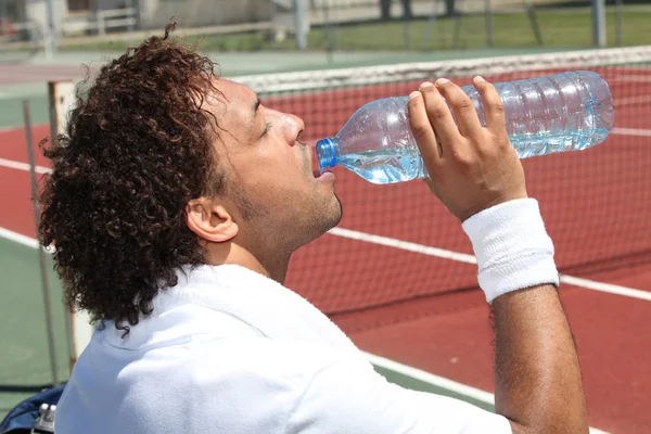 Jogador de tênis água potável — Fotografia de Stock