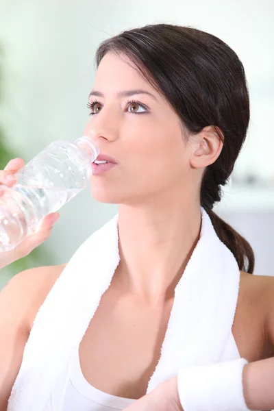 Женщина пьет бутылку воды после тренировки — стоковое фото
