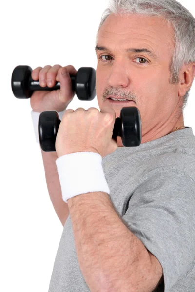 Człowiek zniesienie dumbbells na siłowni — Zdjęcie stockowe